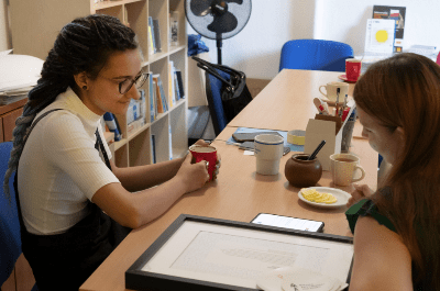 Dwie młode kobiety rozmawiają przy herbacie. 